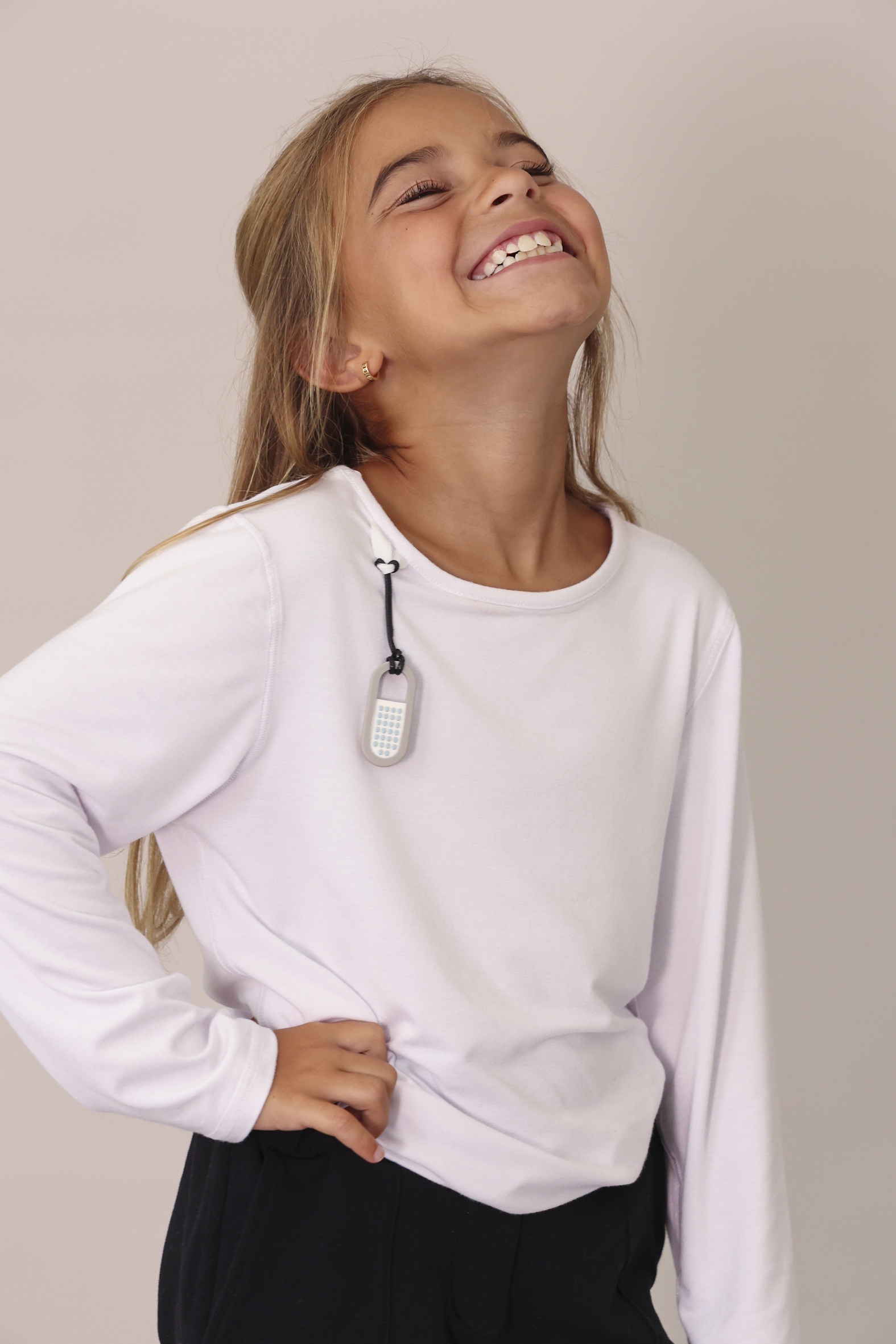 Meisje draagt de Zen Chewy Fidget aan shirt met lus.