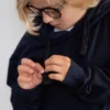 Kind friemelt rustig aan de hoodie-veter, een detail dat laat zien hoe de fidget hoodie kind helpt bij focus en regulatie.