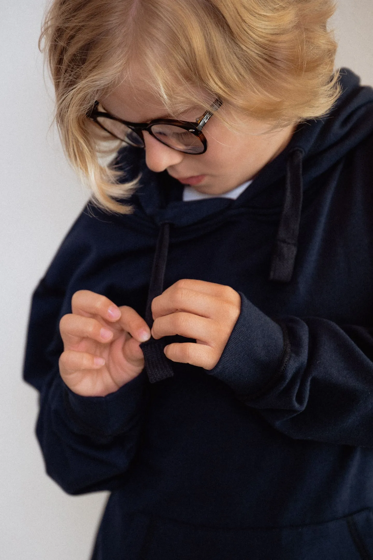 Kind friemelt rustig aan de hoodie-veter, een detail dat laat zien hoe de fidget hoodie kind helpt bij focus en regulatie.