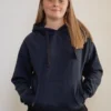 Tiener draagt een zachte, prikkelarme fidget hoodie in marineblauw; ontspannen uitstraling en comfortabele pasvorm.
