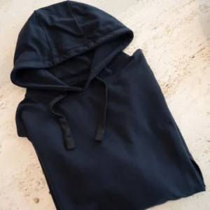 Marineblauwe fidget hoodie voor kinderen, netjes opgevouwen om de zachte stof en eenvoudige afwerking te tonen.