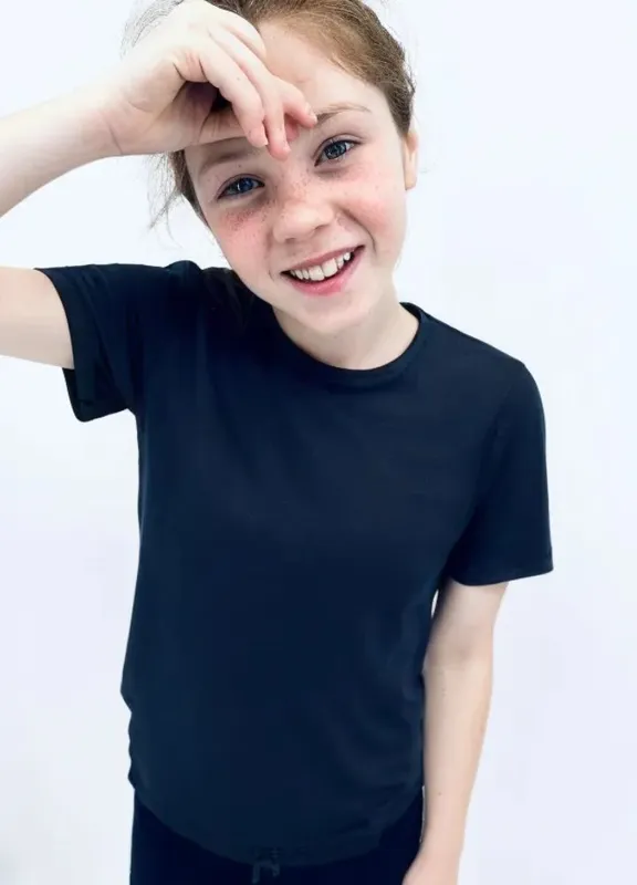 Kind draagt een blauw prikkelarm T-shirt kind zonder labels of binnennaden.