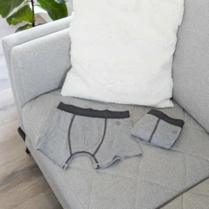 Grijze sensorische boxershort jongens, zacht en labelvrij, op een bank gelegd.
