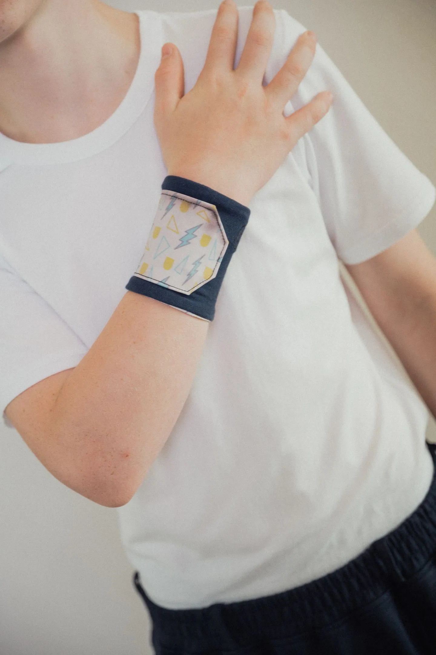 Kind draagt sensory sleeve met kleurverandering om pols