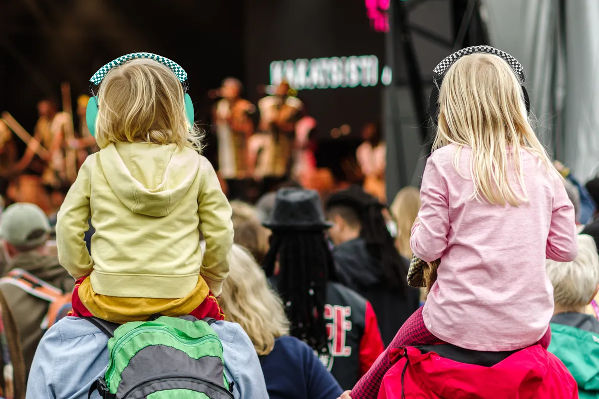 Kinderen dragen gehoorbescherming tijdens een druk evenement met muziek
