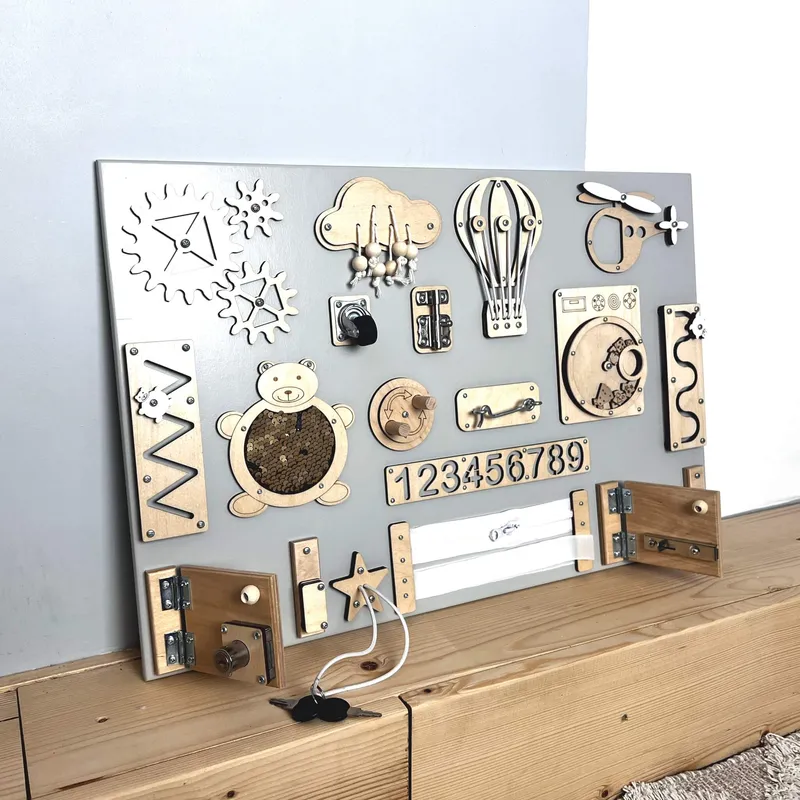 Montessori busy board schuin gefotografeerd tegen muur