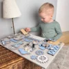 Kind speelt geconcentreerd met Montessori busy board