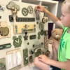 Kind speelt geconcentreerd met sensorisch busy board